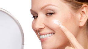 Woman applying cosmetic  cream on a clean fresh face