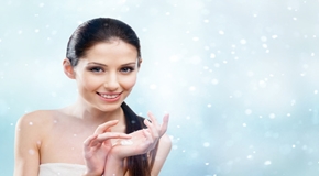 Woman starting to apply protective winter cream, snowy background